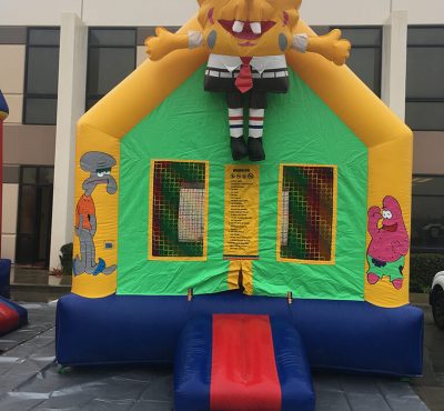 Colorful Spongebob-themed bounce house rental set up in a backyard, ready for children's entertainment and play.