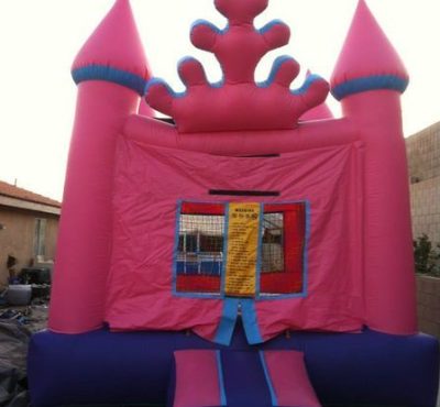 A pink and blue inflatable bouncer featuring a castle design on top, ideal for children's play and entertainment.
